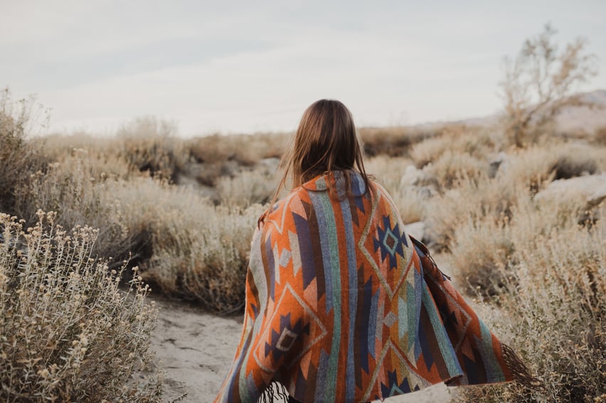 Boho woman with windy hair in the desert nature